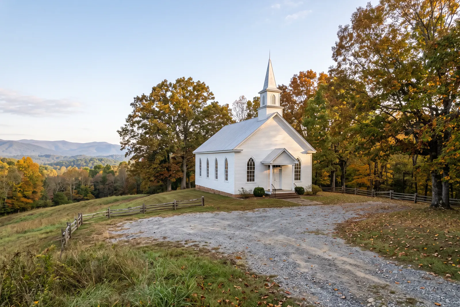 Illustrative image: a white wooden country church with a steeple on a hillside, a gravel lot, autumn trees and blue mountains in the distance.
