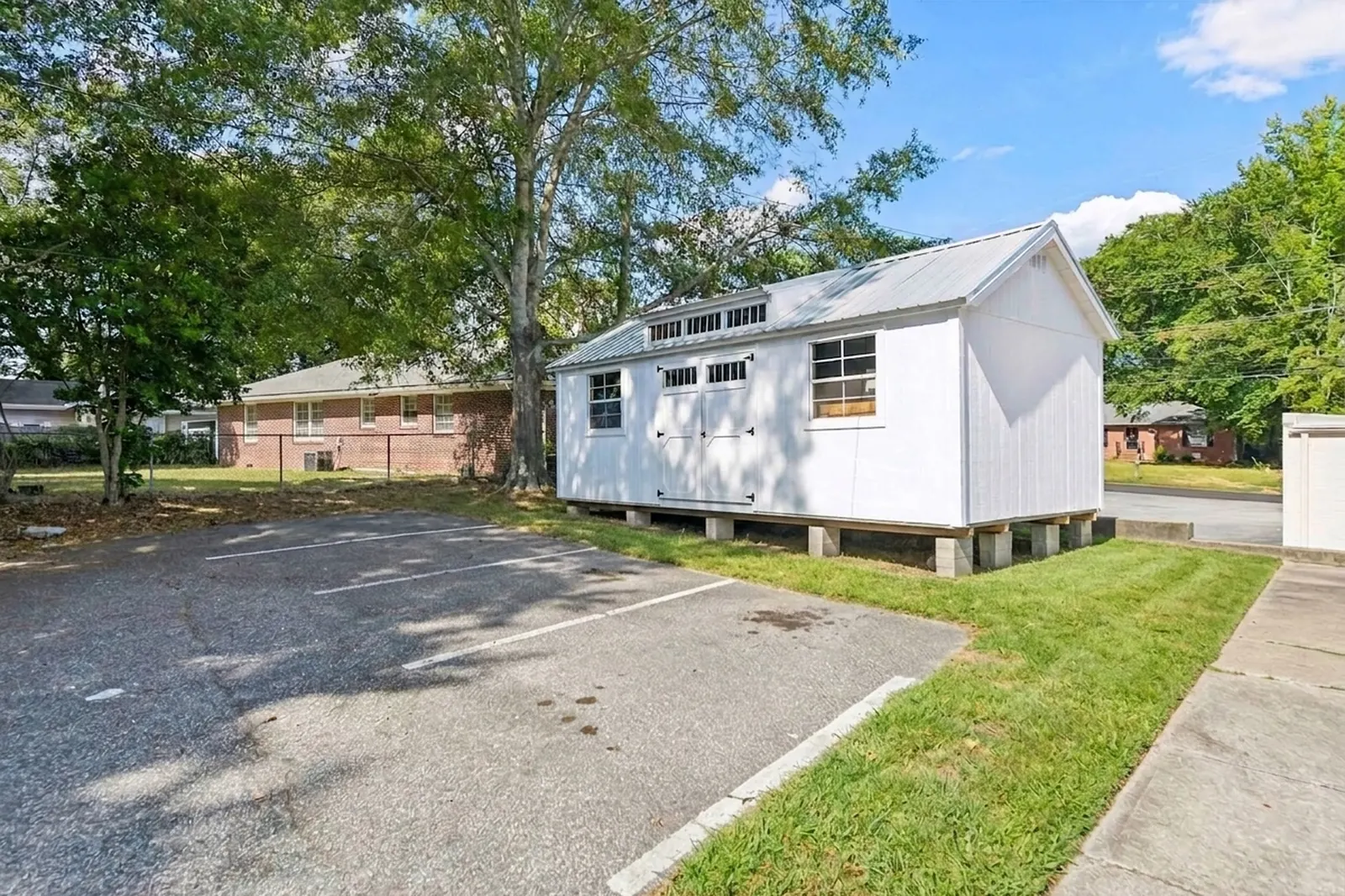 After: the same rear lot and white storage building with the vehicles removed.
