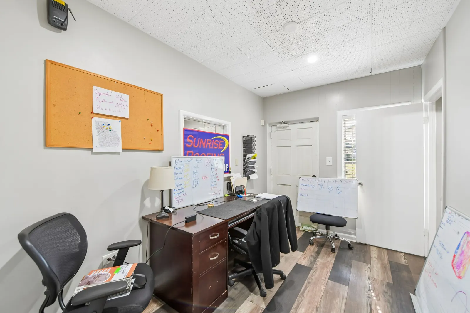 Before: a small office with a cluttered desk, two desk chairs, a cork board, a whiteboard and papers on the floor.